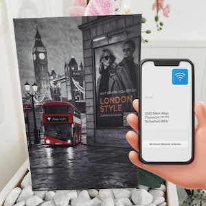 Op de afbeelding: Een zwart-wit print van Londen met een rode dubbeldekkerbus, Big Ben en de Tower Bridge. Een smartphone toont een Wi-Fi verbindingsscherm. De print bevat de tekst "LONDON STYLE" en "Free WiFi".