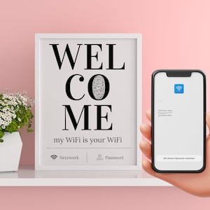 Könnte beinhalten: Ein weißer gerahmter Druck mit dem Text "WELCOME my WiFi is your WiFi" und Symbolen für Netzwerk und Passwort. Eine Hand hält ein Smartphone, auf dem ein Bildschirm mit einer WiFi-Netzwerkverbindung angezeigt wird.