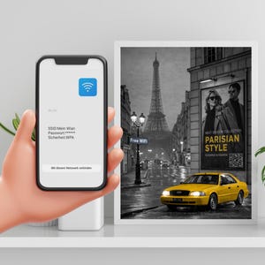 Könnte beinhalten: Ein Smartphone zeigt WLAN-Details. Ein gerahmtes Schwarz-Weiß-Bild von Paris zeigt den Eiffelturm, ein gelbes Auto und eine "Parisian Style"-Werbung. Es gibt auch ein "Free WiFi"-Schild.