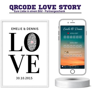 Könnte beinhalten: Ein weiß gerahmtes Bild mit einem schwarz-weißen Design, das "LOVE" mit einem QR-Code im "O" sagt. Das Datum "30.10.2015" ist unter dem Design gedruckt. Ein weißes Telefon mit einem schwarzen Bildschirm ist neben dem Bild zu sehen. Der Bildschirm zeigt einen Kalender mit den Worten "Verliebt", "Verlobt" und "Verheiratet" und einem Herzsymbol.