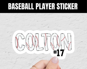 May include: A white baseball player sticker with the name "COLTON" in a baseball stitch font and the number "#17" in black. The sticker is held by a hand.