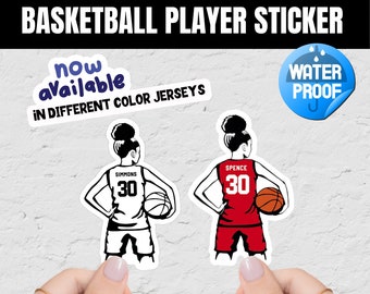 May include: Two basketball player stickers, one in white and one in red, with the number 30 on the back of each jersey. The text "SIMMONS" and "SPENCE" are above the numbers. The text "now available in different color jerseys" is in a blue oval. The text "WATER PROOF" is in a blue circle with raindrops.