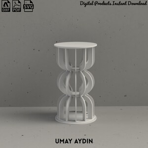 May include: A white cylindrical side table featuring a repeating vertical cutout pattern. The structure consists of a circular top and base connected by curved, interlocking panels. The text "Digital Products Instant Download" and "UMAY AYDIN" appear.