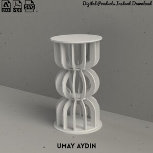 May include: A white, cylindrical, multi-tiered stand featuring a series of vertical, curved slats arranged in three distinct sections. The structure includes a flat circular top and base. The text Digital Products Instant Download and UMAY AYDIN are visible.