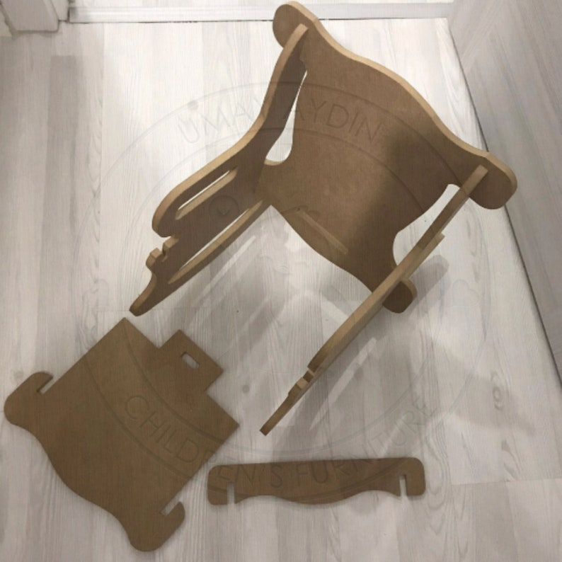 May include: A disassembled wooden chair with a child-sized seat. The chair is made of unfinished wood and has a simple design. The chair is in four pieces, including the seat, back, and two side pieces.