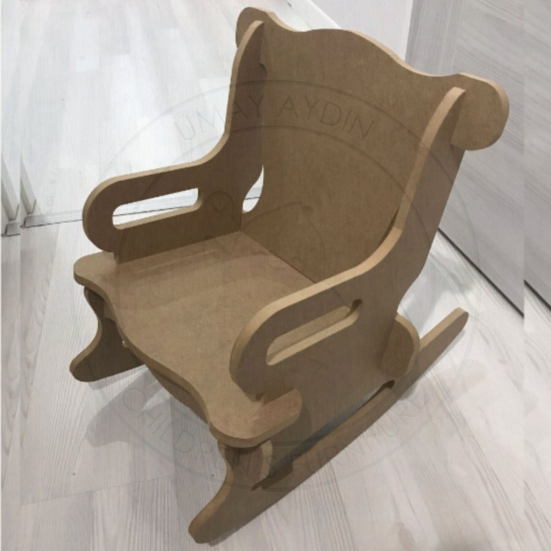 May include: A wooden rocking chair for children, made of unfinished plywood. The chair has a high back and armrests, and the rocking base is visible.