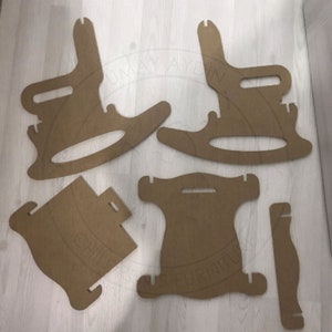 May include: A set of six cardboard pieces for assembling a rocking chair. The pieces are brown and have cutouts for assembly.