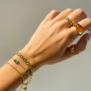 18k gold agate ring on hand with irregular stone ring and stacked gold bracelet chains