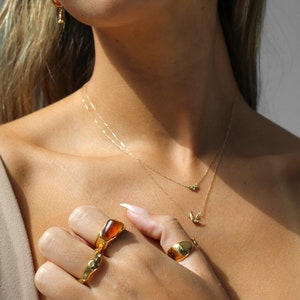 agate irregular gemstone ring in 18k gold on hand with other rings