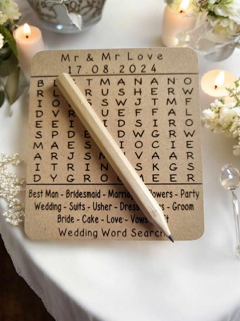May include: A brown card with a wedding word search puzzle. The puzzle features the words "Mr. & Mr. Love" and "17.08.2024". The words "Best Man", "Bridesmaid", "Marriage", "Flowers", "Party", "Wedding", "Suits", "Usher", "Dress", "Bride", "Cake", "Love", "Vows", and "Groom" are listed below the puzzle.