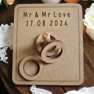 May include: A wooden sign with the text "Mr & Mr Love 17.08.2024" and a wooden ring toss game.