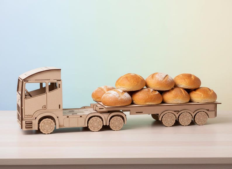 May include: A wooden toy truck transporting a stack of fresh, golden-brown bread rolls. The truck is made of light-coloured wood and has detailed cutouts. The rolls are round and appear freshly baked, suggesting a bakery or food theme.