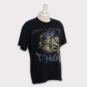 May include: Black t-shirt featuring a graphic of the University of North Carolina Tar Heels mascot, a ram wearing a sailor hat, and the text "Tar Heels" in a stylised font.
