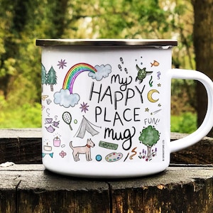 Könnte beinhalten: Weiße Emaille-Camping-Tasse mit einer Schwarzweiß-Illustration eines Regenbogens, eines Zeltes, eines Hundes, einer Farbpalette und anderer Camping-Motive. Die Tasse hat einen schwarzen Griff und einen silbernen Rand. Der Text "my happy place mug" ist in Schwarz auf der Tasse geschrieben.