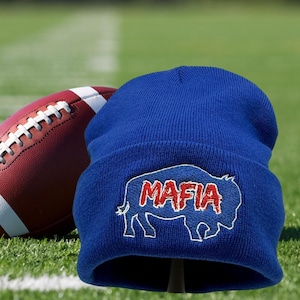 May include: Royal blue beanie with a white outline of a buffalo with the word "MAFIA" in red and white lettering.