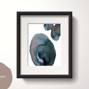 May include: Framed abstract watercolor art print. The artwork features organic shapes in shades of blue, green, and brown against a white background. The black frame complements the artwork. The print is from RosieJene Art Company.