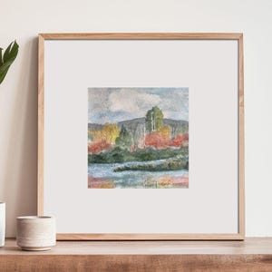 May include: Watercolor painting of a landscape with a lake, trees, and a cloudy sky. The trees are in shades of green, yellow, and red, and the lake is a light blue color.