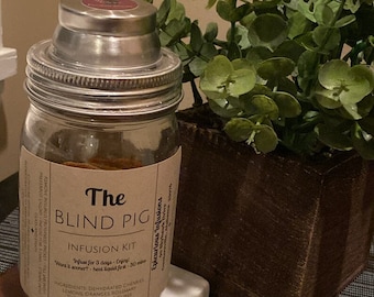 May include: A glass jar with a metal lid filled with dried citrus, herbs, and sugar cubes. The jar is labeled "The Blind Pig Infusion Kit" and includes instructions to infuse for 3 days.