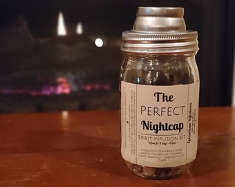 May include: A glass jar with a metal lid and a brown label that reads "The Perfect Nightcap Spirit Infusion Kit - Infuse for 3 days - Enjoy!" The label lists ingredients including dehydrated apples, lemons, cranberries, cinnamon, cloves, star anise, turbinado sugar, and cubes.