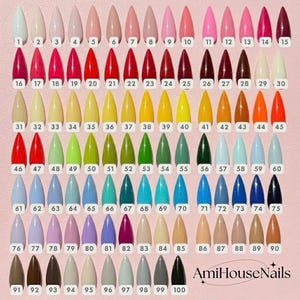 May include: A display of 100 nail polish color swatches in a variety of shades, from light neutrals to vibrant hues. Each swatch is numbered and has a pointed tip. The brand name "AmiHouseNails" is visible at the bottom.