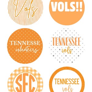 May include: Six circular stickers featuring orange and white designs. One has vertical stripes with "Vols" in script, one is solid orange with "VOLS!!", one has white polka dots with "TENNESSEE volunteers", one has plus signs with "TENNESSEE vols", one has a gingham pattern with "SEC" in a monogram, and one has a geometric border with "TENNESSEE vols".