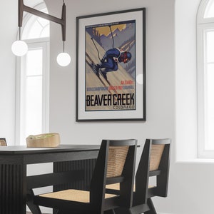 May include: A vintage poster advertising Beaver Creek, Colorado, a North American Grand Mountain Resort. The poster features a skier in a blue and red suit racing down a snowy mountain slope. The text on the poster reads "Alt. 11440ft. World Championship Skiing - Kings of Frey Downhill. Beaver Creek, Colorado."