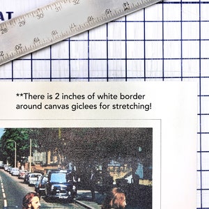 May include: A black and white photo of the Beatles walking across a street. The photo is printed on canvas with a 2 inch white border around the edges for stretching.