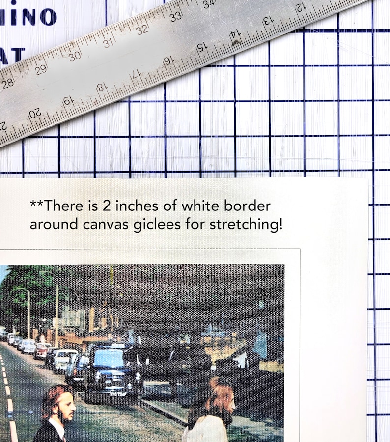 May include: A black and white photo of the Beatles walking across a street. The photo is printed on canvas with a 2 inch white border around the edges for stretching.