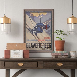 May include: A vintage poster advertising Beaver Creek, Colorado, a ski resort in the Rocky Mountains. The poster features a skier in a blue and red suit, a mountain landscape, and the text "North America's Grand Mountain Resort", "Alt. 11,440 ft.", "World Championship Birds of Prey Downhill", "Beaver Creek", and "Colorado".