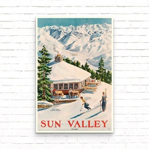 Puede incluir: Un cartel de viaje vintage para Sun Valley, Idaho, que presenta un paisaje monta&ntilde;oso nevado con una caba&ntilde;a de esqu&iacute; y esquiadores. El cartel tiene un cielo azul, nieve blanca y un logotipo rojo y blanco con el texto "Sun Valley, Idaho".
