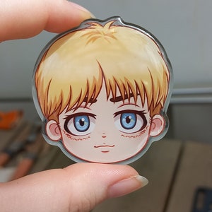 Peut inclure: Un charme rond en acrylique transparent repr&eacute;sentant une illustration de dessin anim&eacute; d'une jeune personne aux cheveux blonds, aux yeux bleus et au teint rose clair. Le charme mesure environ 5 cm de diam&egrave;tre.