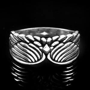 May include: A silver-toned metal ring featuring a symmetrical wing design that wraps around the band. The surface of the ring has a polished finish with darkened recessed areas to highlight the detailed feather textures and a central diamond shape.