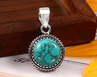 May include: A silver pendant with a turquoise stone set in a decorative silver frame. The stone has a marbled pattern.