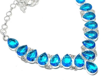 May include: A silver necklace with a chain and teardrop-shaped blue gemstones.