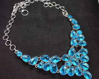 May include: A silver necklace with a teardrop-shaped pendant made of many light blue gemstones.