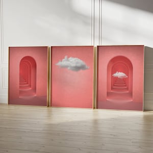Puede incluir: Tres impresiones enmarcadas con un fondo rosa. Las impresiones de la izquierda y la derecha presentan un pasillo de arcos que conducen a una nube. La impresión central presenta una sola nube sobre un fondo rosa.
