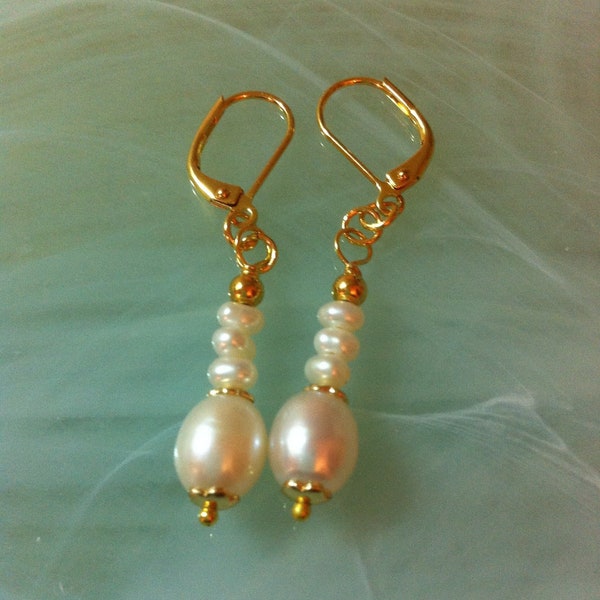Des perles d'eau douce, une perle comme une goutte et surmontée de trois petites perles d'eau douce enjolivées de petites coupelles fleuries