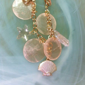 Sea charm bracelet with an Angel Aura point quartz, pink mother-of-pearl shell disks, a pink Swarovski crystal starfish, a two-sided pink