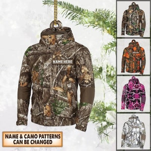 May include: A personalized camo jacket ornament with the text "NAME HERE" on the front. The ornament is available in different camo patterns.