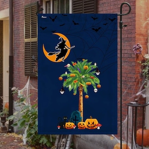 May include: A Halloween-themed garden flag with a silhouette of a witch flying on a crescent moon, a palm tree decorated with pumpkins and skulls, and a black cat sitting near a tombstone. The background is a dark blue with a spiderweb design.