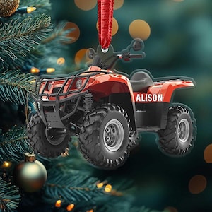 May include: A red and black ATV ornament with the name "ALISON" printed on the side. The ornament has large, black tires and a red ribbon for hanging. The ATV has a black front grill and a black seat.