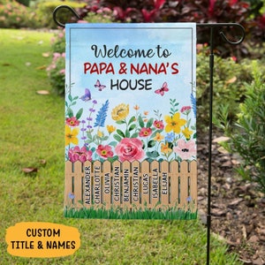 May include: A colorful garden flag with a blue sky background and a wooden fence with names on it. The text reads "Welcome to Papa & Nana's House".