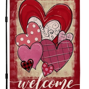 May include: A red and pink Valentine's Day garden flag with a welcome message and a design of multiple hearts. The hearts are in various shades of pink and red with different patterns, including polka dots, plaid, and a black and white checkered pattern.