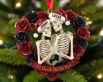 May include: Heart-shaped Christmas ornament featuring two skeleton figures embracing, surrounded by red and black roses. The skeletons wear Santa hats with the names "Jenny" and "Lucas." A banner reads "Til Death Do Us Part."