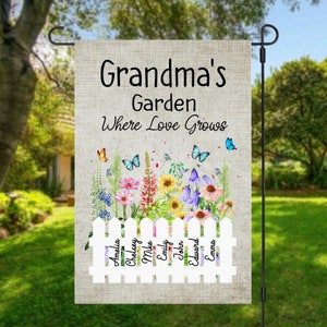 May include: A garden flag with a white picket fence and the text "Grandma's Garden Where Love Grows". The fence has names on each picket: Amelia, Chelsey, Mike, Emily, John, Edward, and Emma. The flag has a floral design with butterflies.