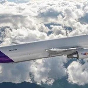 May include: A FedEx Express cargo airplane flies through a cloudy sky. The aircraft is white with purple accents on the tail and the FedEx logo. The FedEx logo is also visible on the engine.