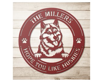 May include: Red metal sign with a husky dog peeking over the top. The sign reads "The Millers Hope You Like Huskies".