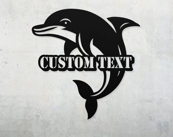 May include: Black metal silhouette of a dolphin jumping out of the water with the text "CUSTOM TEXT" underneath.