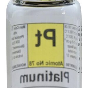 May include: A small glass bottle with a black lid containing a silver metallic sphere. The label on the bottle reads "Platinum" and "Atomic no. 78". The lid has the text "Novaelements&reg;" and a colorful atomic symbol.