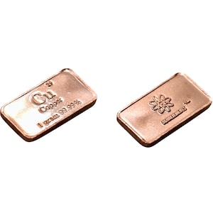 Może przedstawiać: Dwa pręty miedziane, jeden z symbolem chemicznym miedzi, Cu, i słowami "Miedź 1 gram 99,99%", a drugi z symbolem atomu i słowem "Niezwykły".